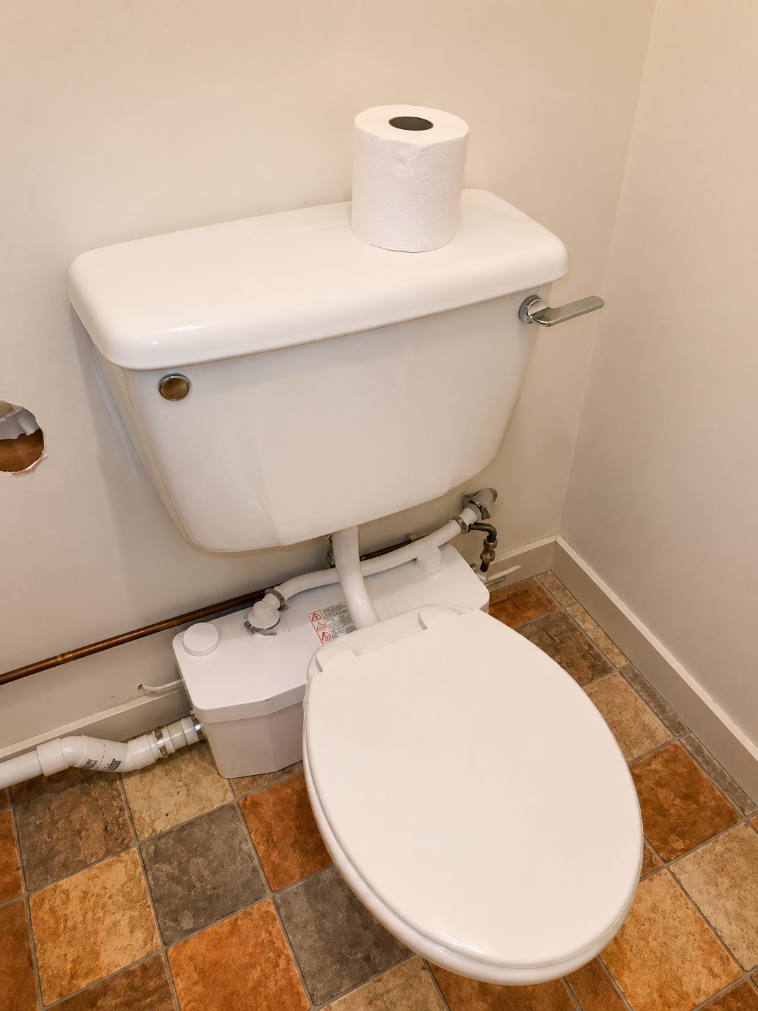 Completed compact toilet with macerator plumbing